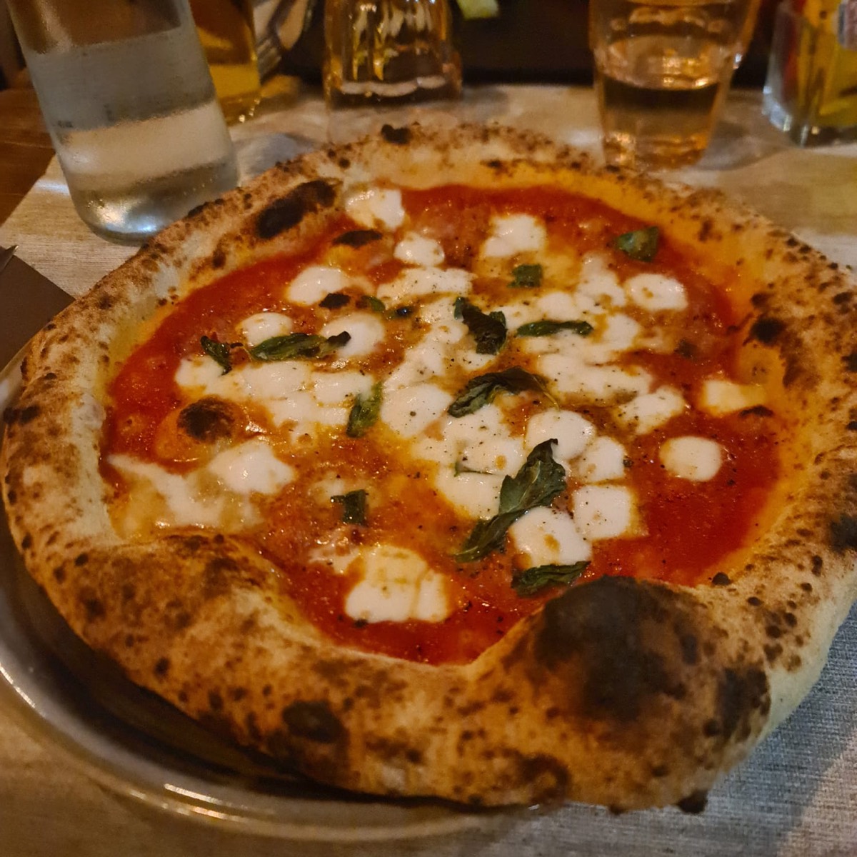 Pizza margherita napoletana con cornicione alto e ben cotto
